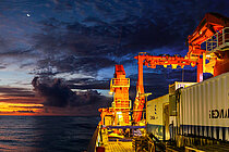 A research vessel with containers on board at sunset at sea