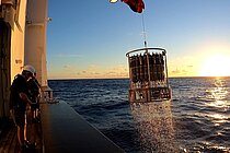  A multiple water sampler is heaved aboard a research vessel at sunset