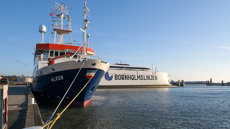 The research vessel ALKOR is moored in the harbour, in the background you can see a large ferry with the name ‘Bornholmslinjen’ written in large letters.
